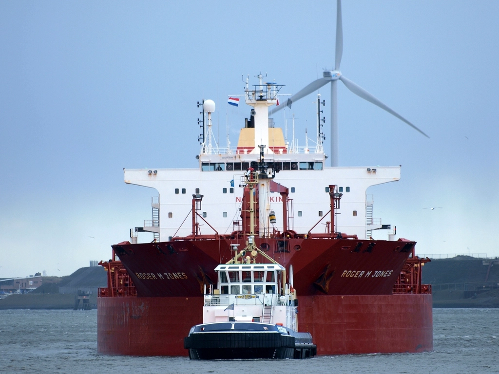 Tugboat assisting a cargo ship in harbor